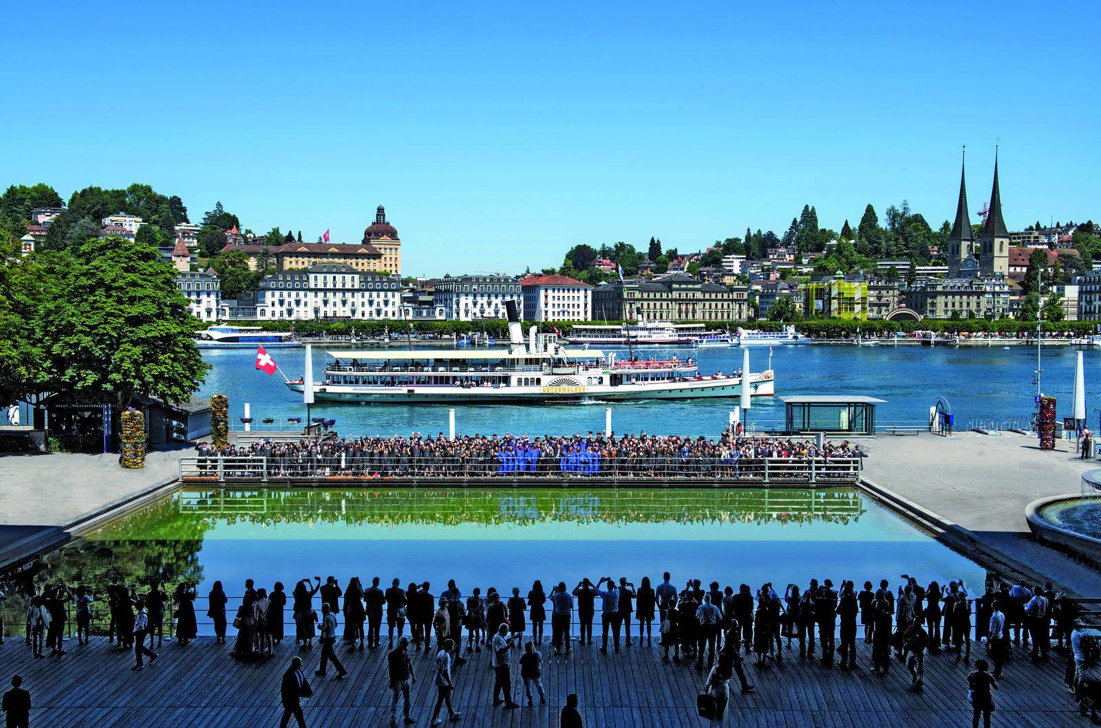 BHMS graduates in gowns gathered on the Lucerne waterfront terrace